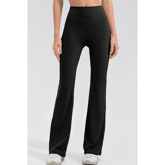 Woman wearing a black wide waistband high waist bootcut active leggings.