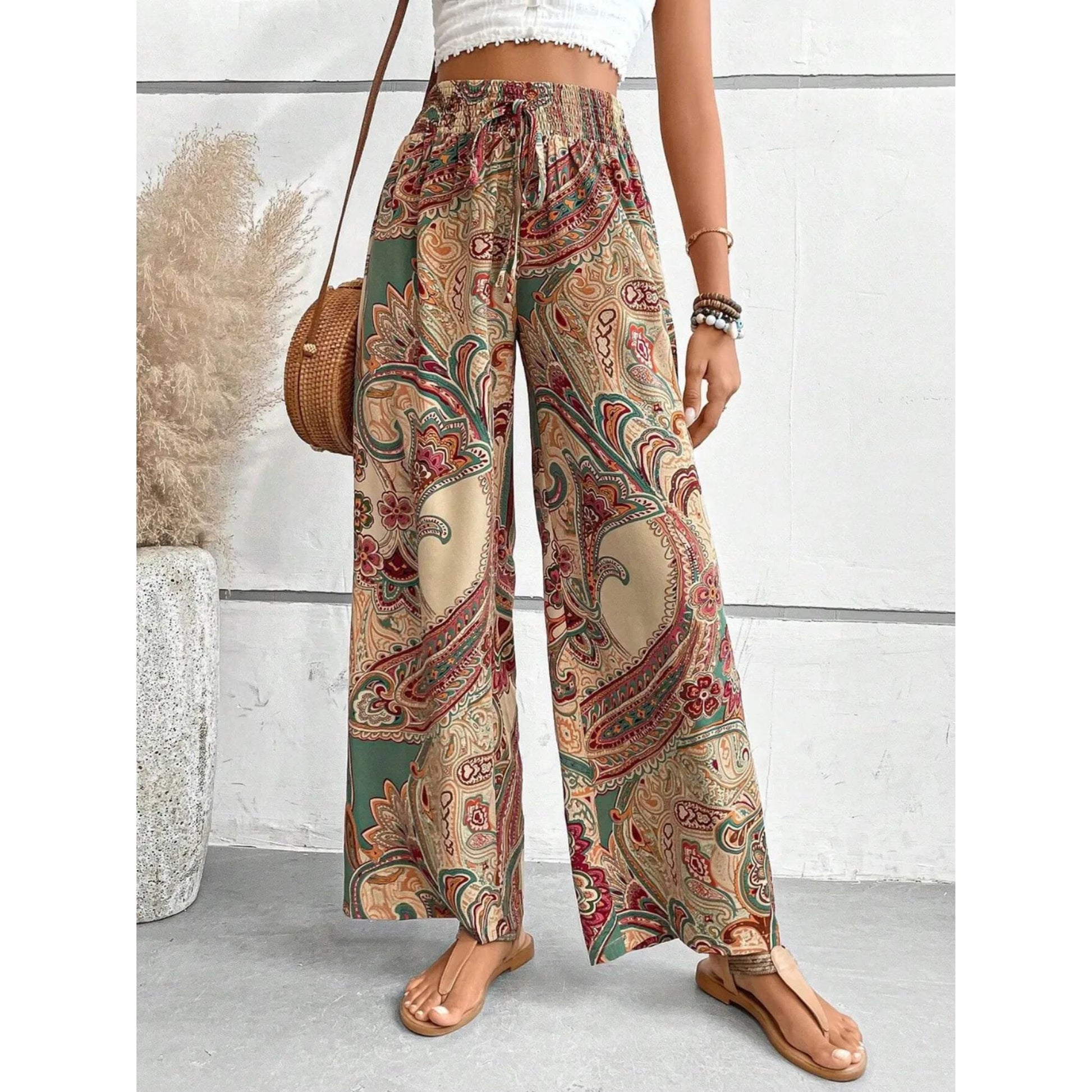 Person wearing patterned wide-leg pants with a white wall background