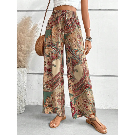 Person wearing patterned wide-leg pants with a white wall background