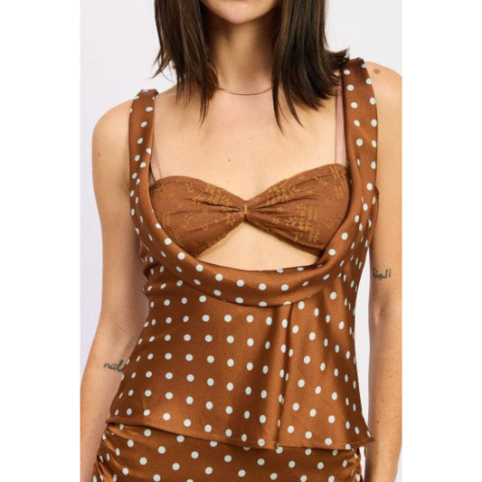 Brown polka dot top worn by a person on a white background