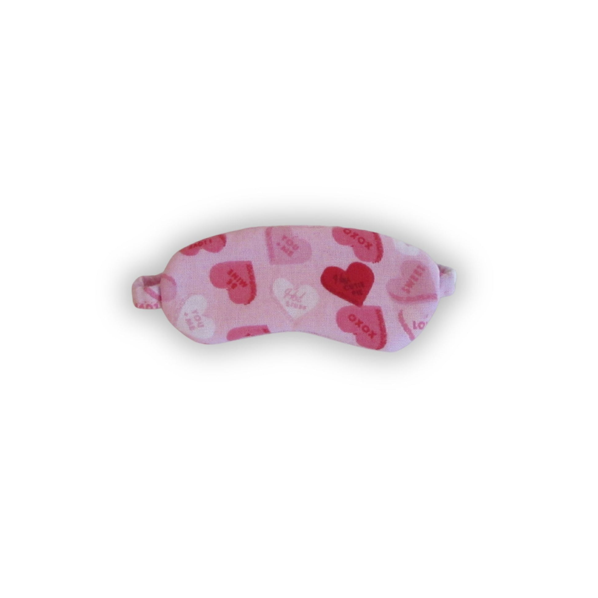 Pink sleep mask with heart patterns on a white background