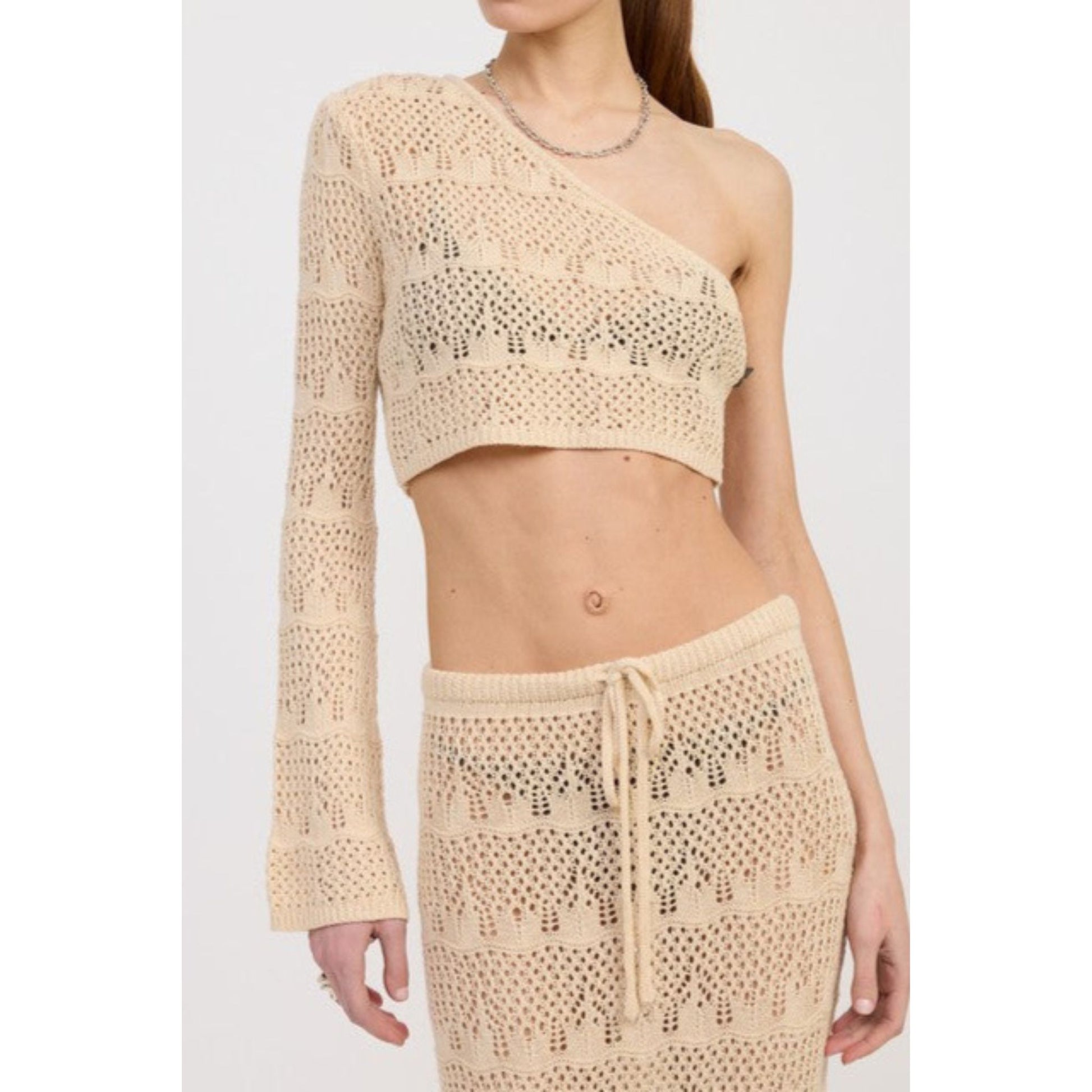 Beige crochet top and skirt set on a plain background