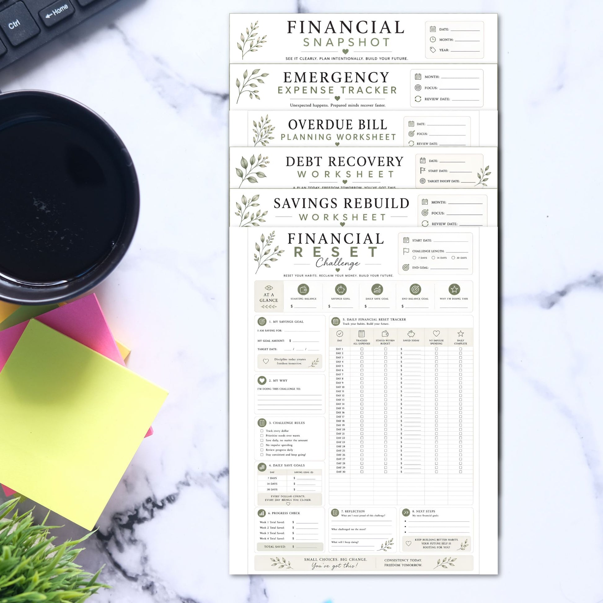 Financial worksheets on a marble surface with a coffee cup and plant.