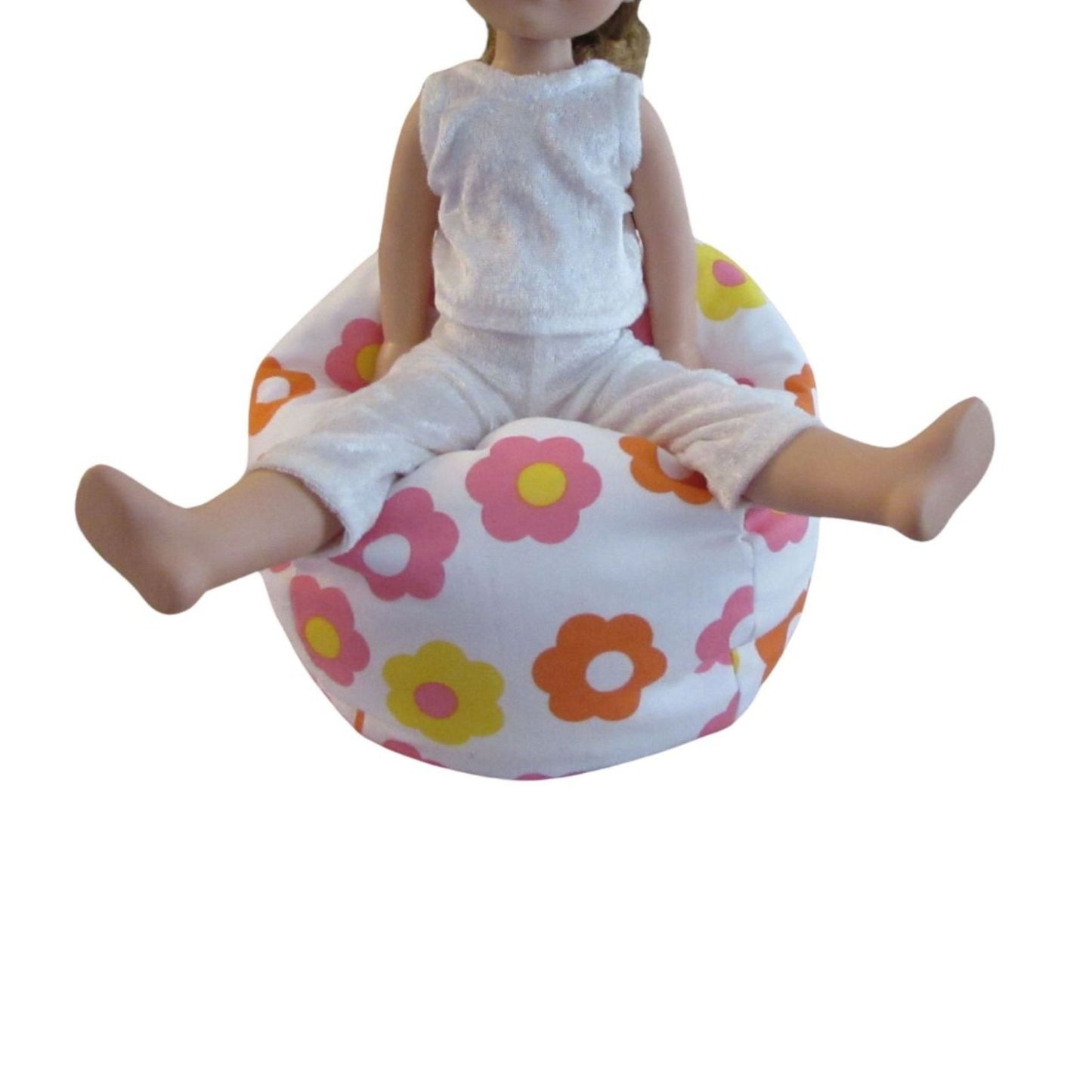 Doll sitting on a colorful floral-patterned cushion against a white background