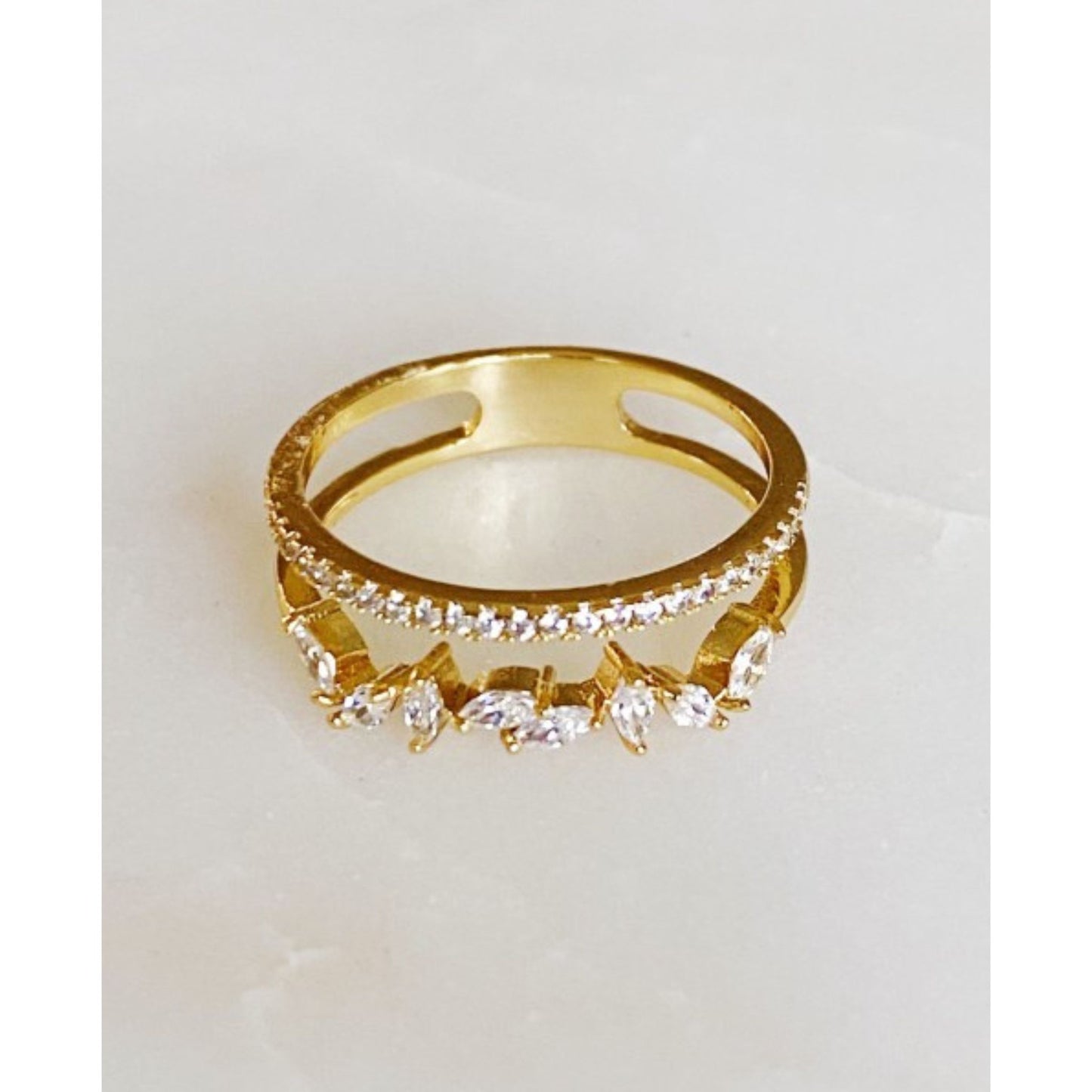 Gold ring with diamond accents on a light gray background