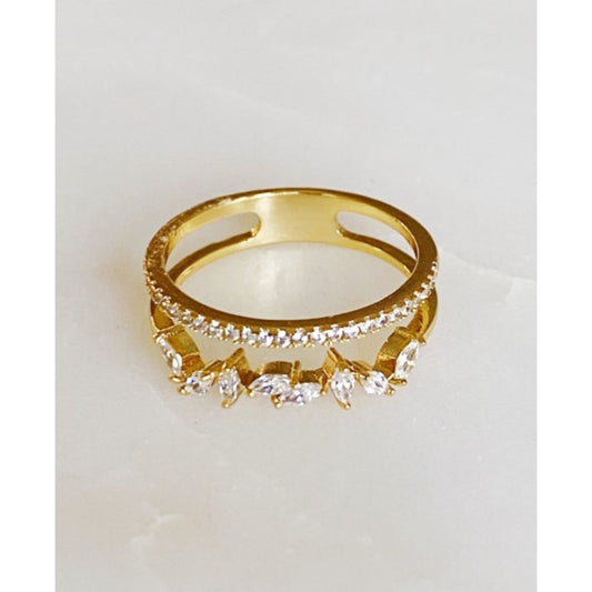 Gold ring with diamond accents on a light gray background