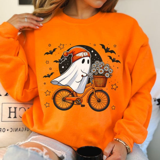 Person wearing an orange sweatshirt with a ghost riding a bike graphic