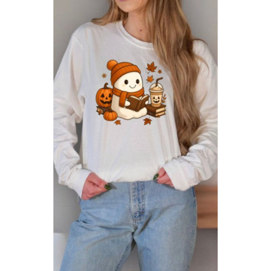 Person wearing a white sweatshirt with a graphic design of a snowman, pumpkin, and hot chocolate.
