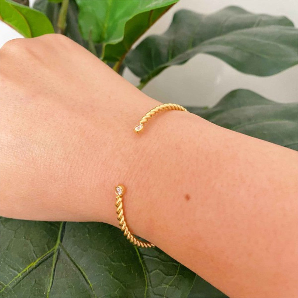 Gold Cabled Open Bangle Bracelet on leaves background