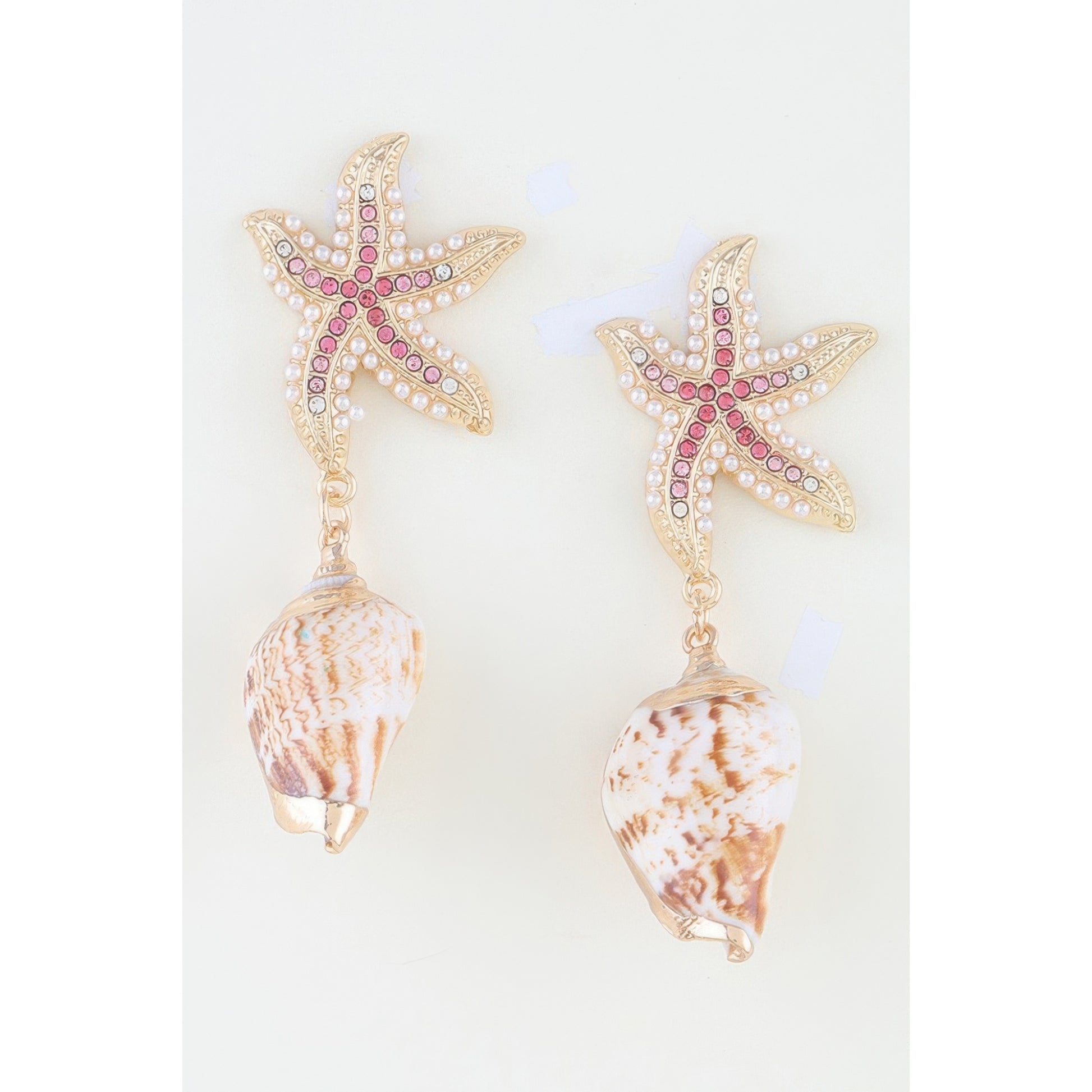 A pair of gold-toned starfish dangle earrings embellished with pink rhinestones and white faux pearls, with realistic seashell charms hanging below, shown against a plain white background.