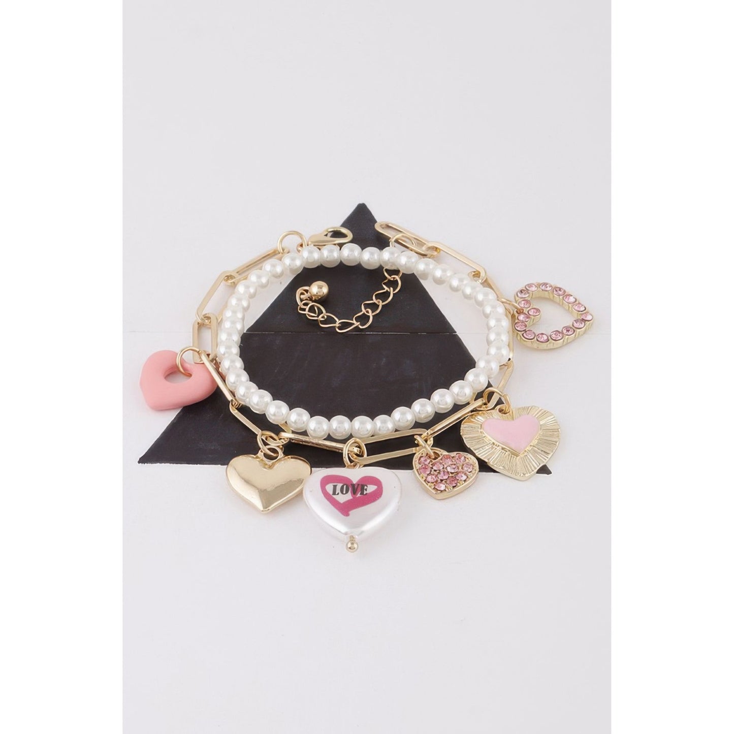 Set of pearl and gold charm bracelets on a white background