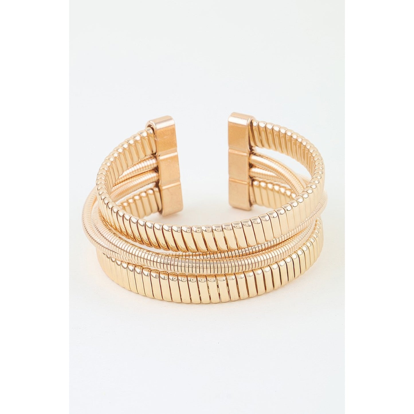 A gold-plated multi-band cuff bracelet with a ribbed, snake-inspired textured design and a rectangular clasp, shown on a plain white background.