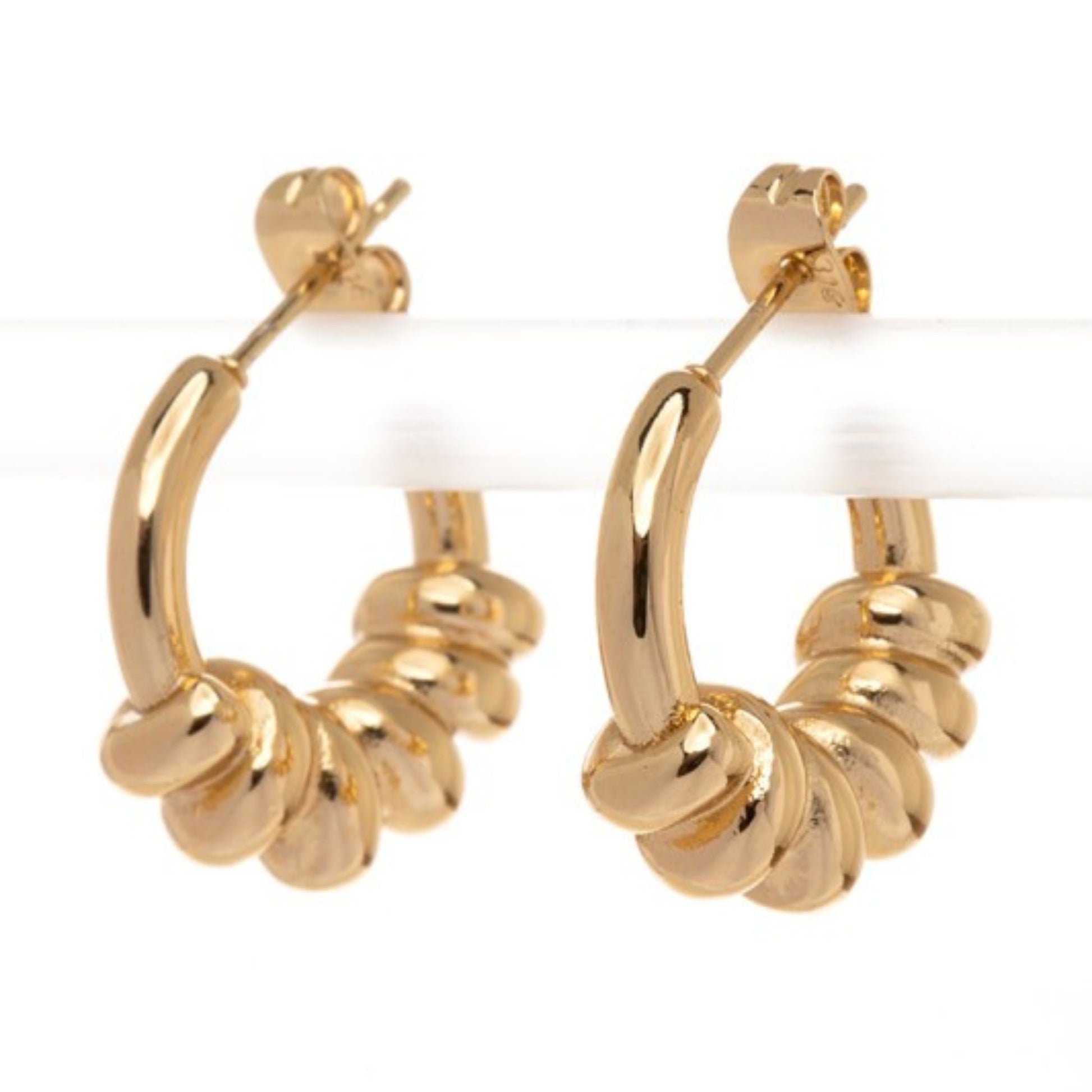 Gold hoop earrings with a textured design on a white background