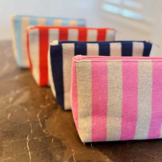 Striped pouches in various colors arranged on a reflective surface.