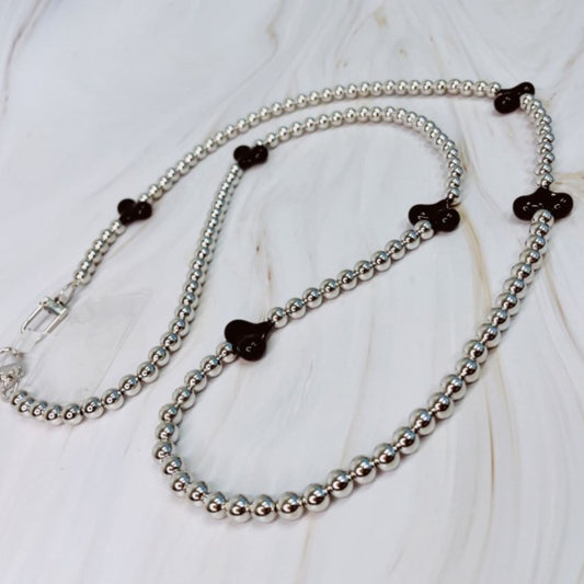 Silver beaded necklace with black heart-shaped beads on a white background