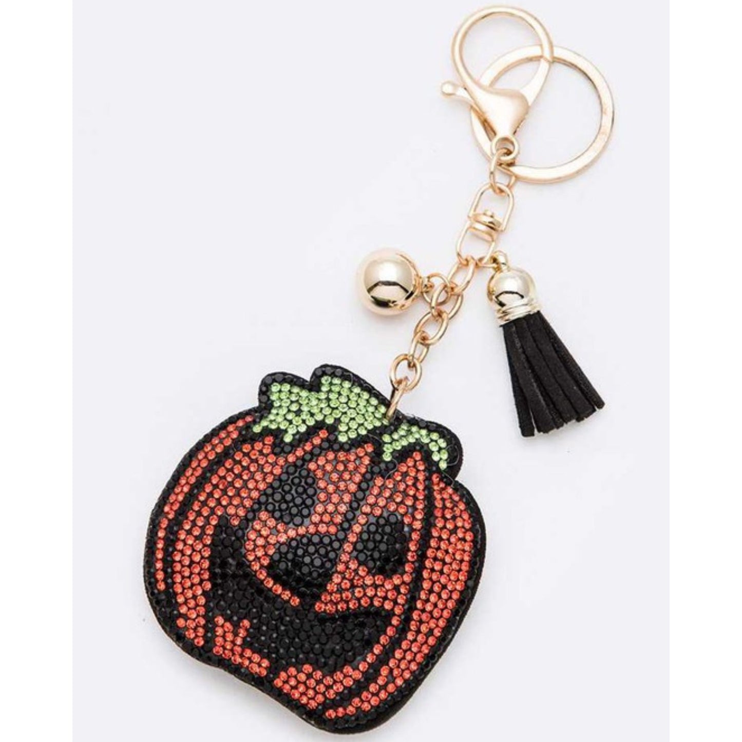 Pumpkin-shaped keychain with rhinestone details on a white background