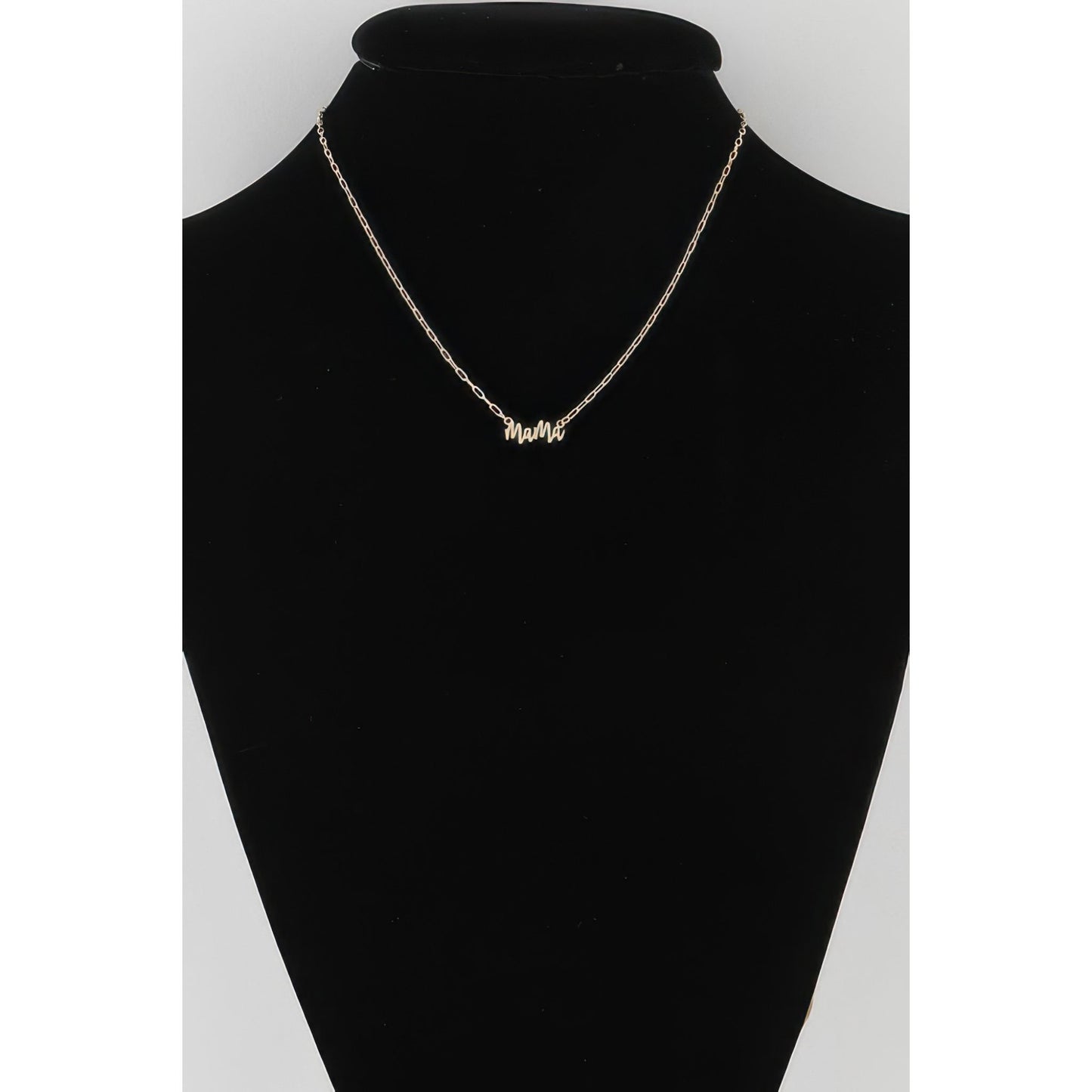 Gold necklace on a black mannequin bust with a white background