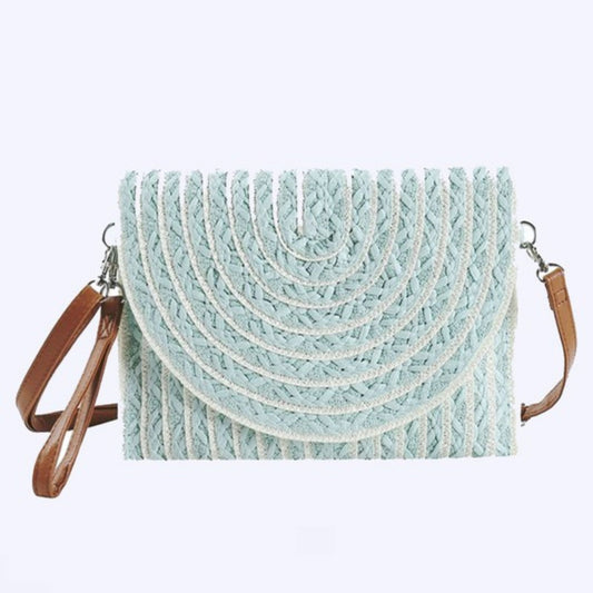 Light blue woven handbag with brown leather straps on a light gray background