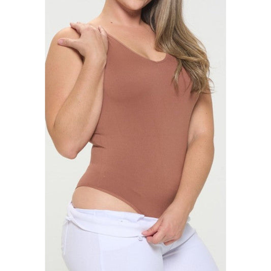 Woman wearing a mocha sleeveless top with a cutout design on a white background