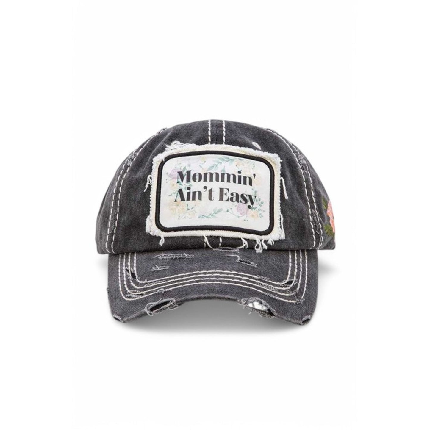 Black distressed baseball cap with 'Mommin' Ain't Easy' patch on a white background