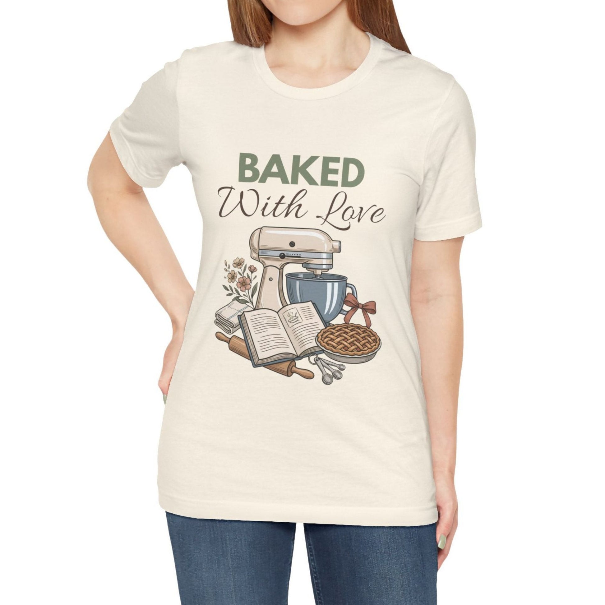 A woman wearing a natural t-shirt with 'BAKED With Love' on the front.