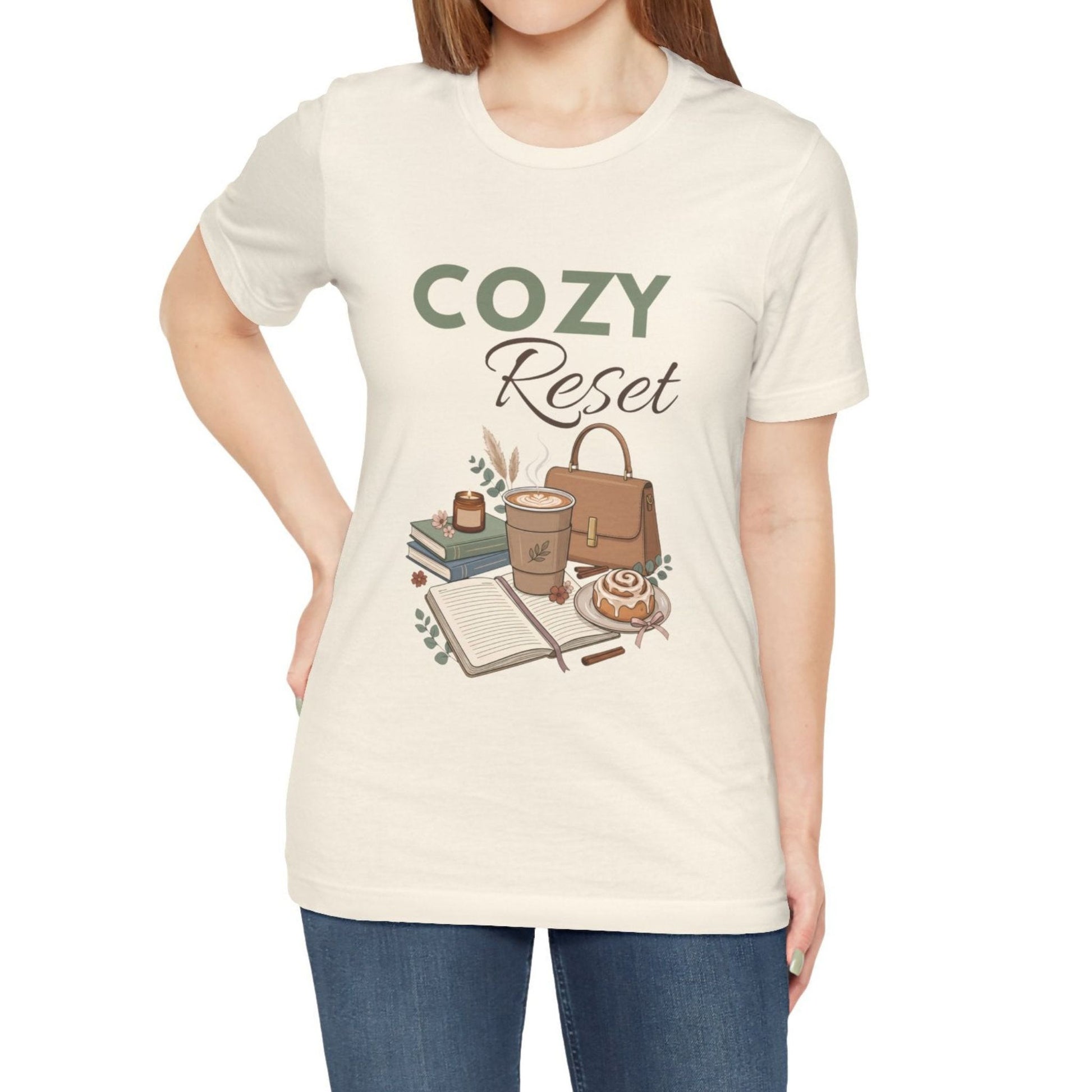 A woman is wearing a natural colored t-shirt with 'COZY Reset' on the front.