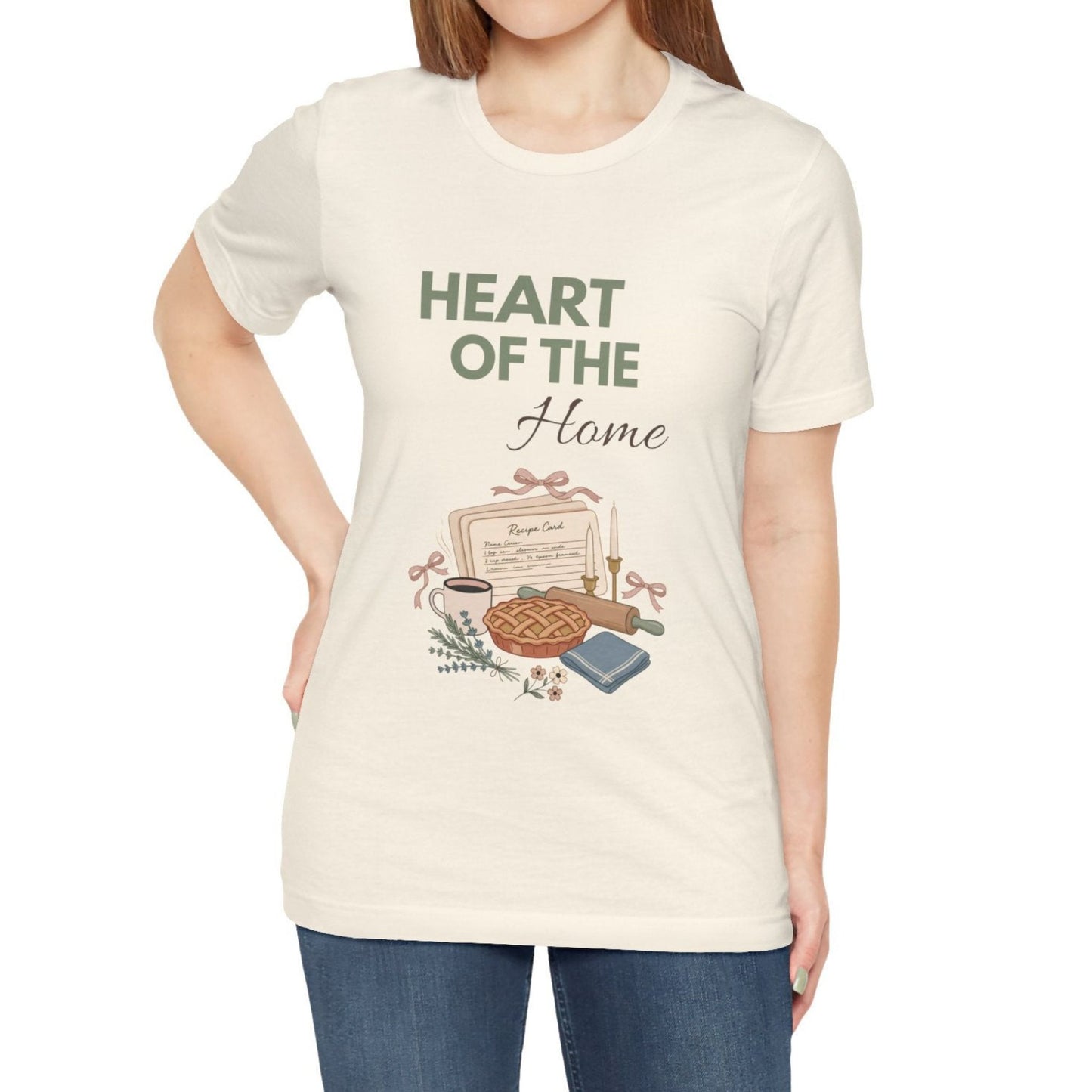 A woman wearing a natural colored t-shirt with 'HEART OF THE Home' on the front.