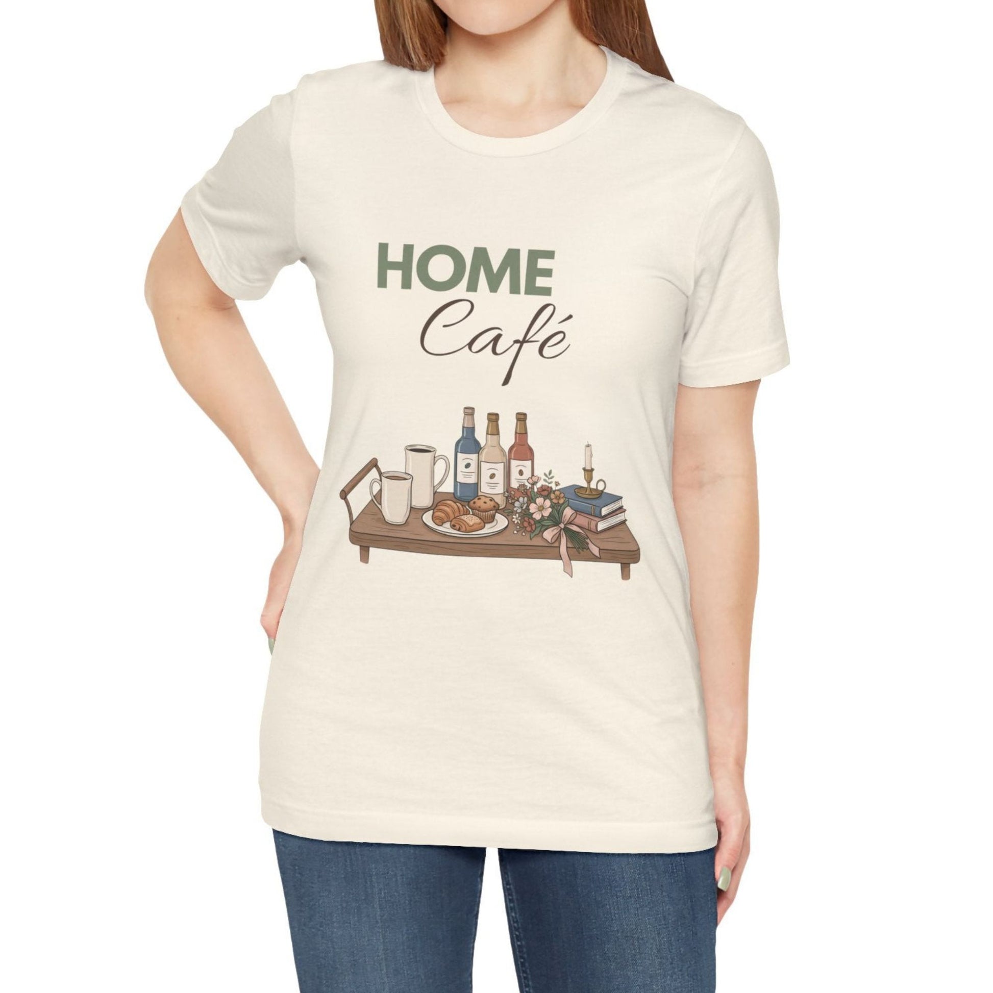 Person wearing a natural colored t-shirt with 'Home Café' graphic design on a white background