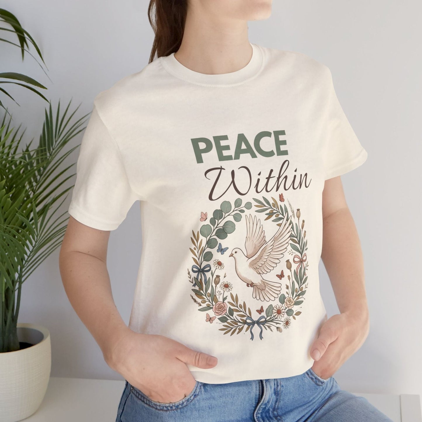 Person wearing a natural colored t-shirt with 'Peace Within' design and text.