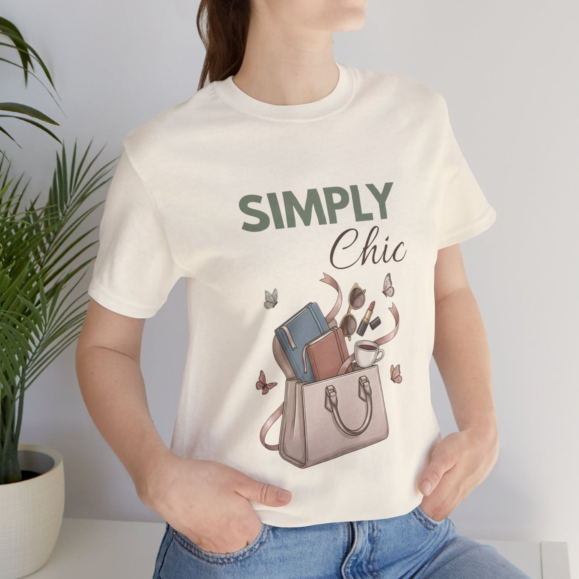 A woman is standing by a plant in a natural colored t-shirt with 'SIMPLY Chic' on the front.