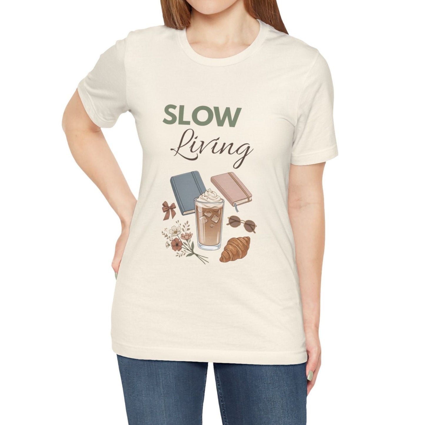 Person wearing a natural colored 'Slow Living' t-shirt with graphics on a white background