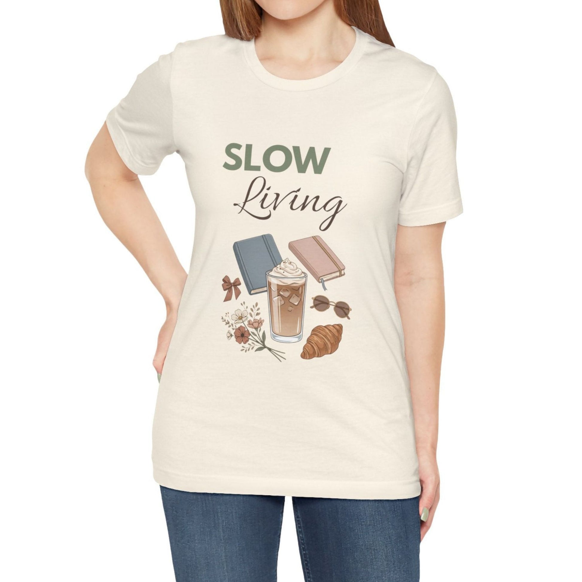 Person wearing a natural colored 'Slow Living' t-shirt with graphics on a white background