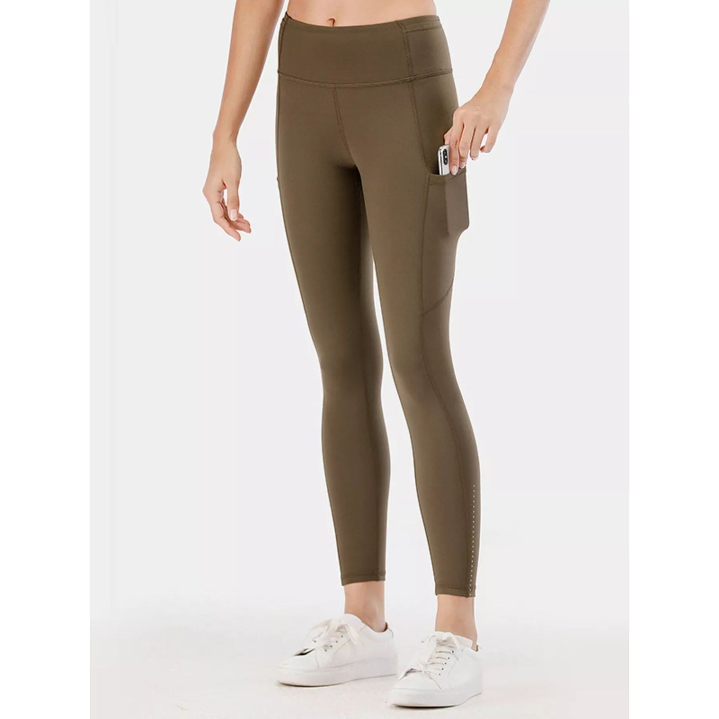 Person wearing olive green leggings on a white background