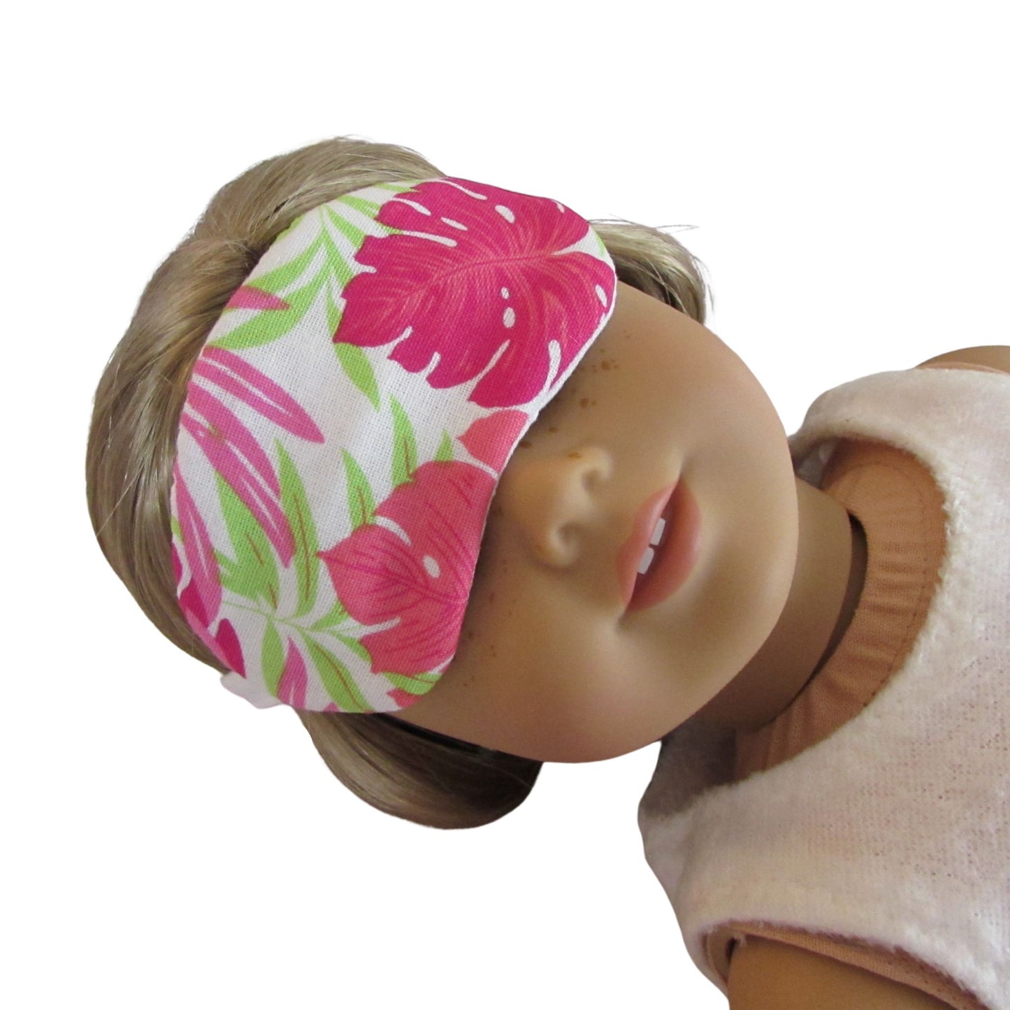 Doll wearing a pink floral headband on a white background