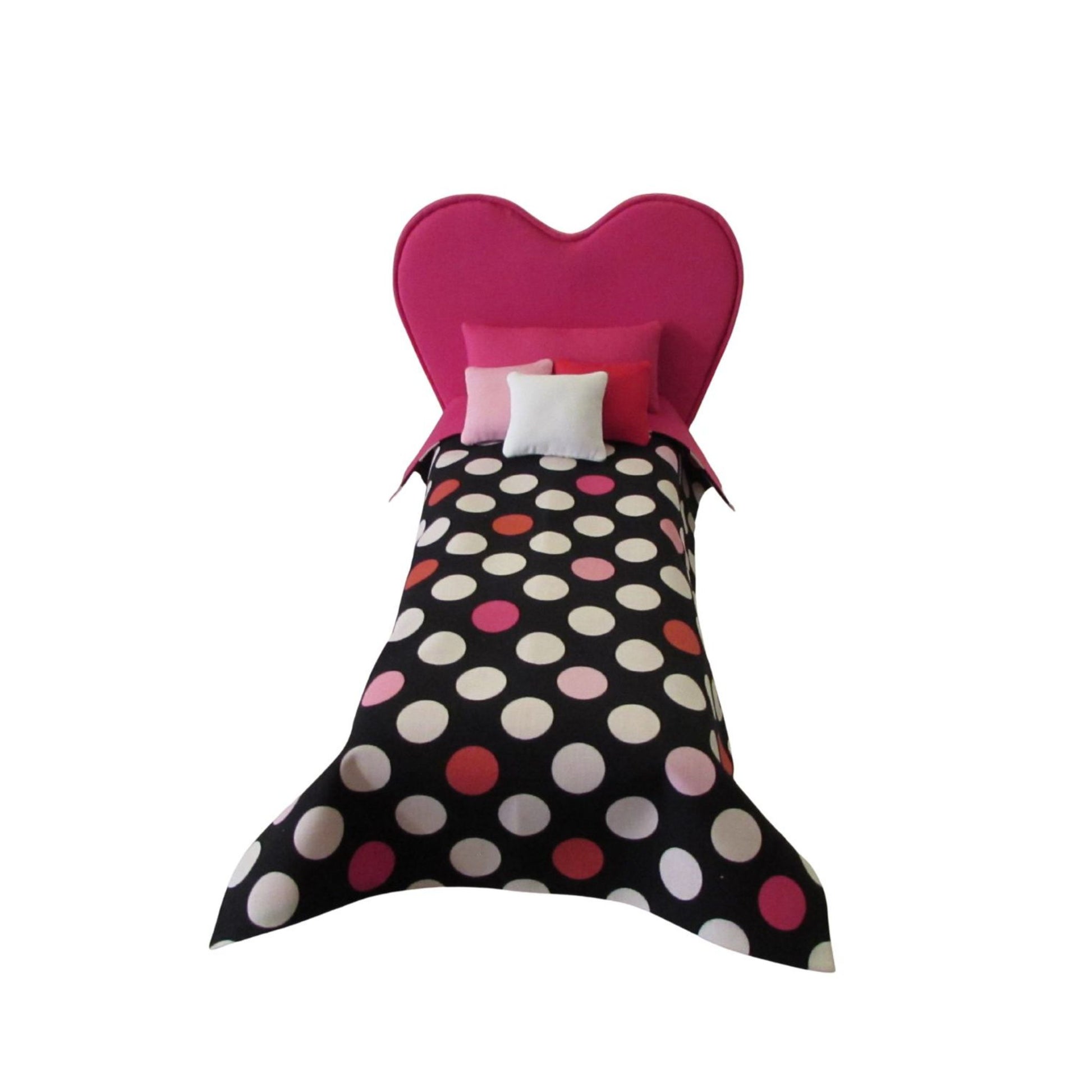 Heart-shaped bed with polka dot bedding on a white background