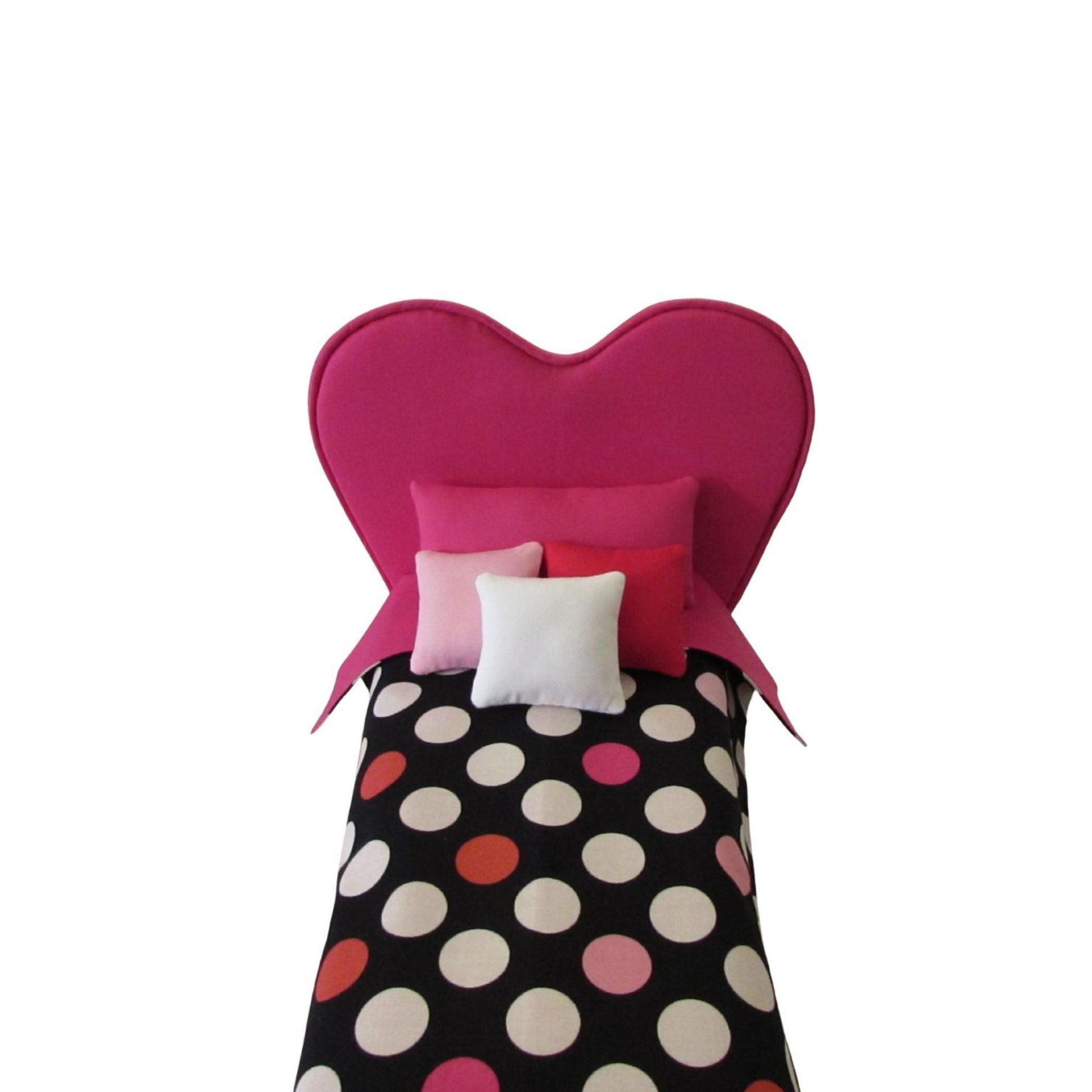 Heart-shaped pink headboard with polka dot bedding on a white background