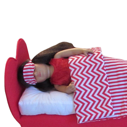Doll with a red and white striped eye mask and chevron-patterned blanket on a white background