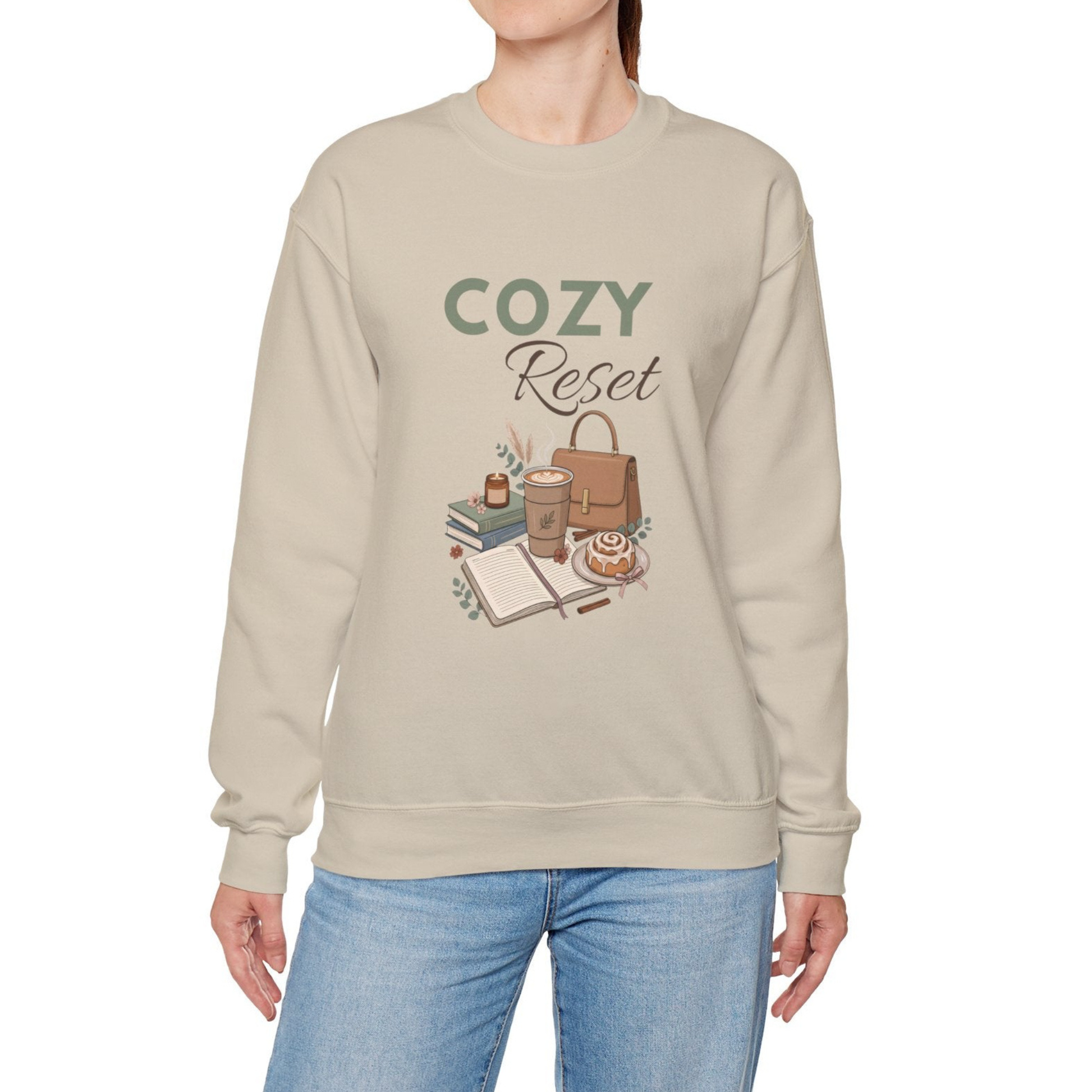 A woman is wearing a sand-colored sweatshirt with 'COZY Reset' on the front.