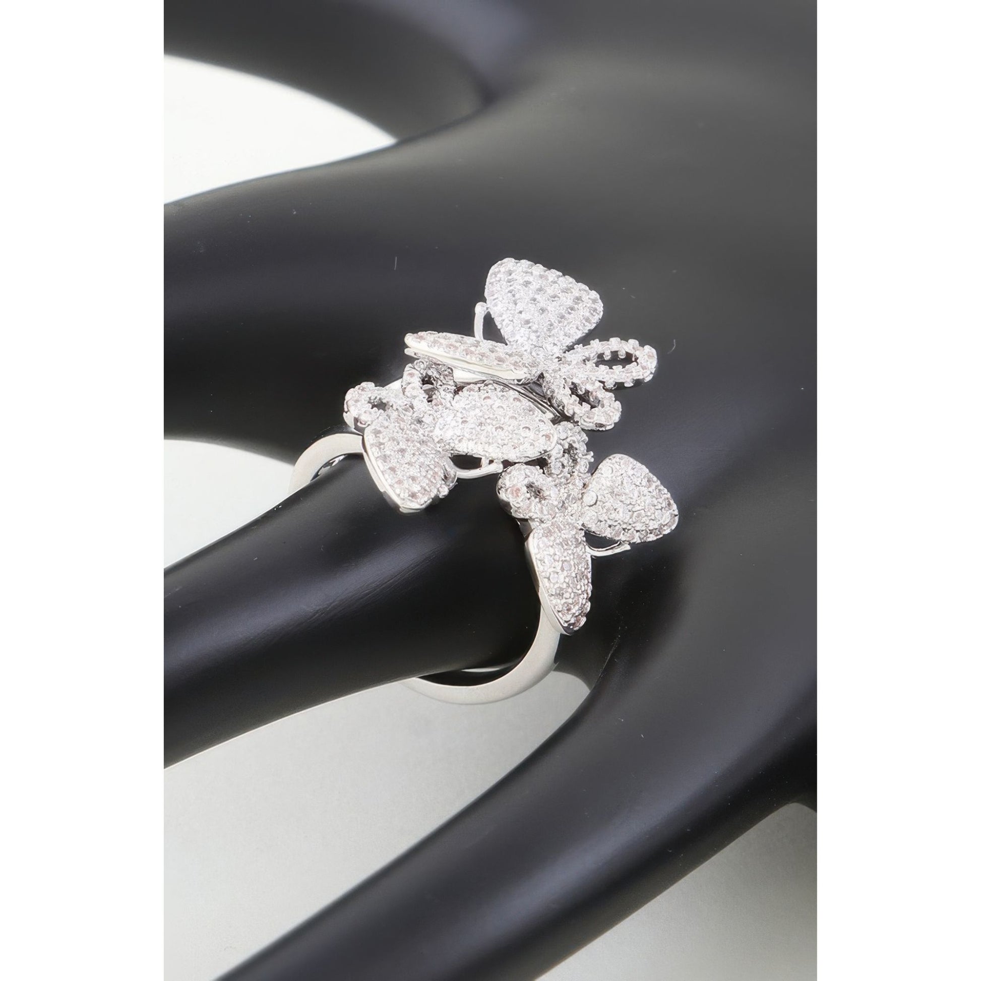Silver butterfly-shaped ring on a black and white background
