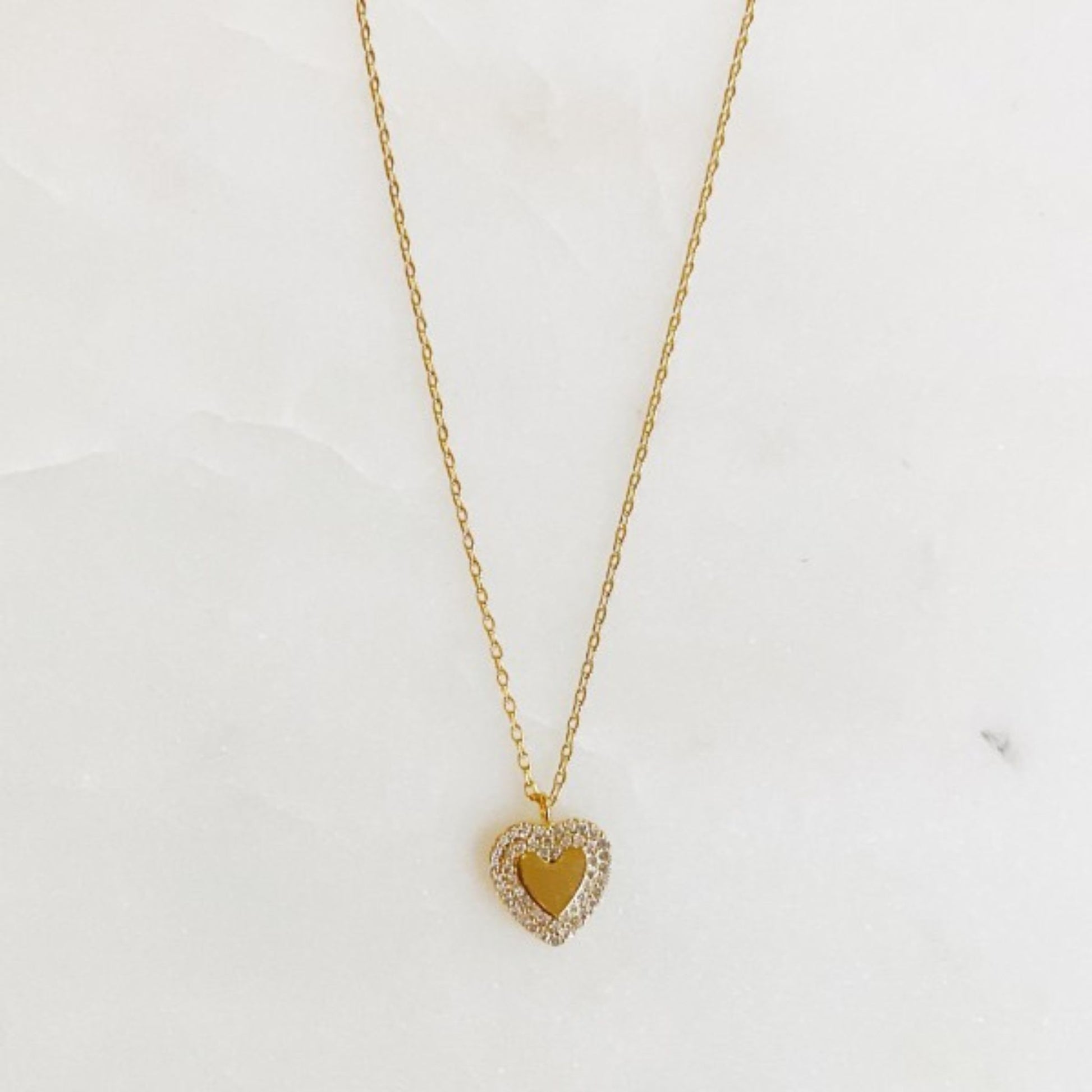 Gold heart-shaped necklace on a white background