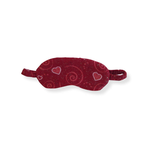 Red sleep mask with heart and swirl patterns on a white background