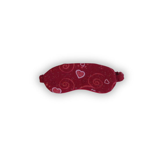 Red sleep mask with heart and swirl patterns on a white background