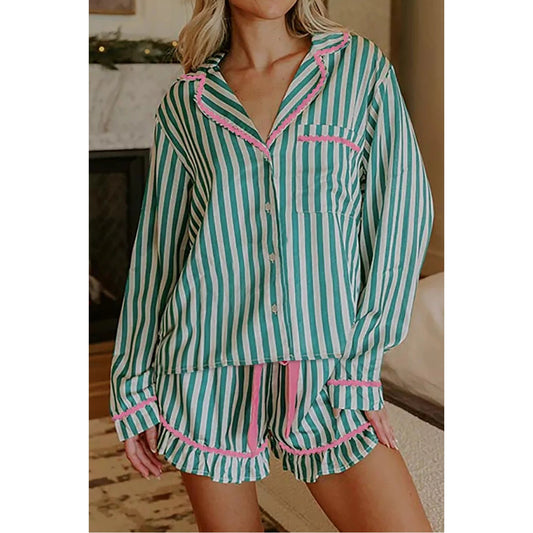A woman wearing a two-piece pajama set with turquoise and white vertical stripes and pink ruffle trim, shown in a home interior setting.