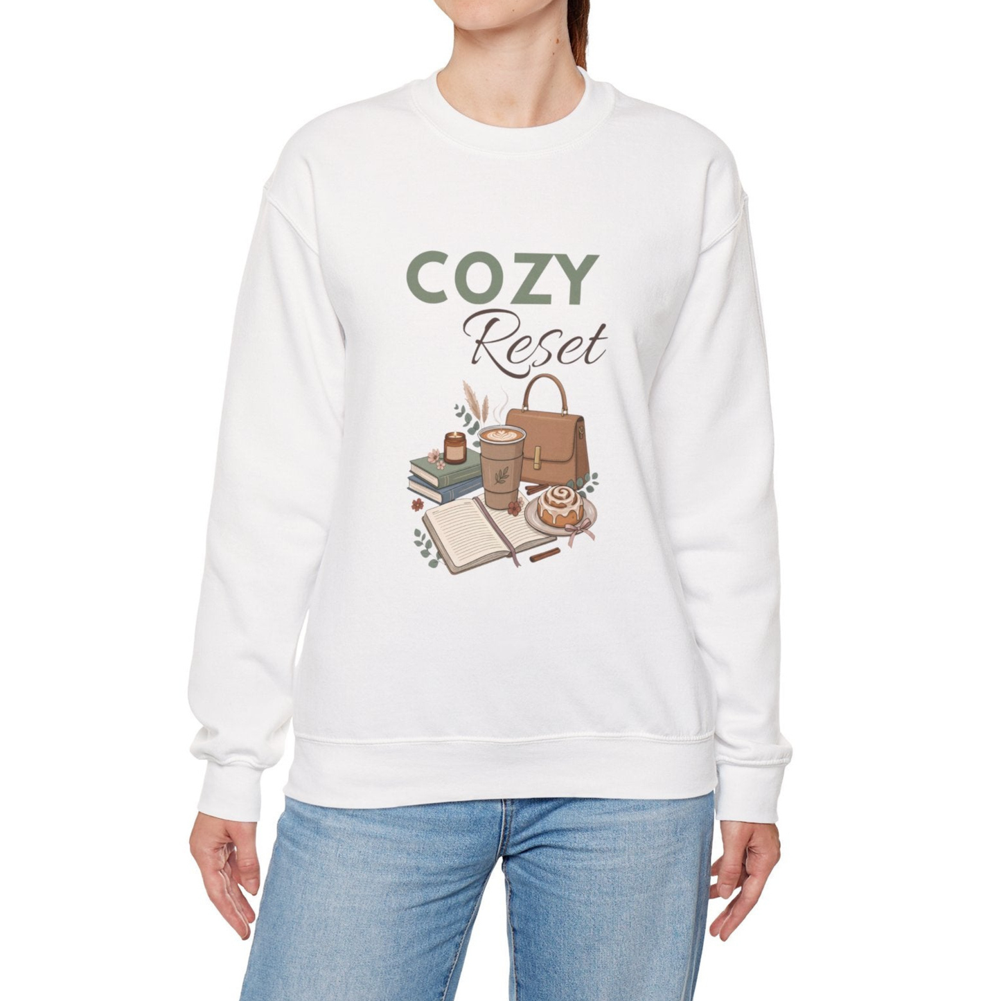 A woman is wearing a white crewneck sweatshirt with 'COZY Reset' on the front.