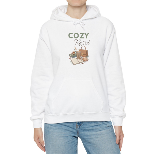 A woman is wearing a white hooded sweatshirt with 'COZY Reset' on the front.