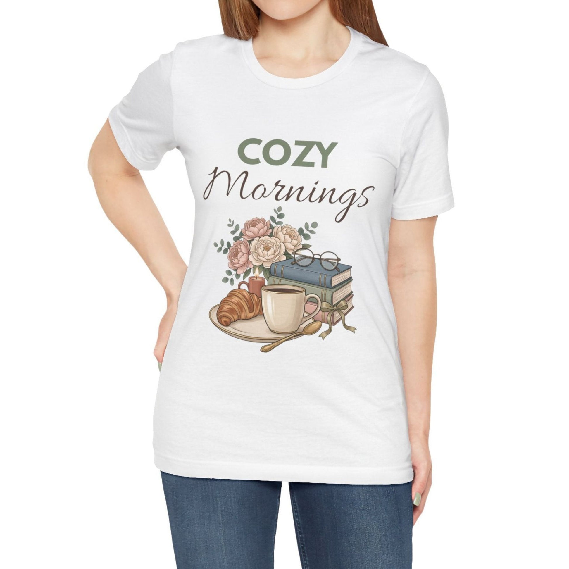 White t-shirt with 'Cozy Mornings' graphic design featuring a coffee cup, croissant, and books.