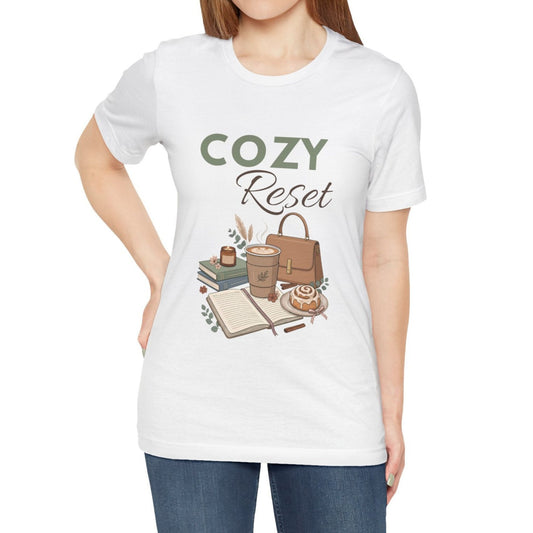 A woman is wearing a white t-shirt with 'COZY Reset' on the front.