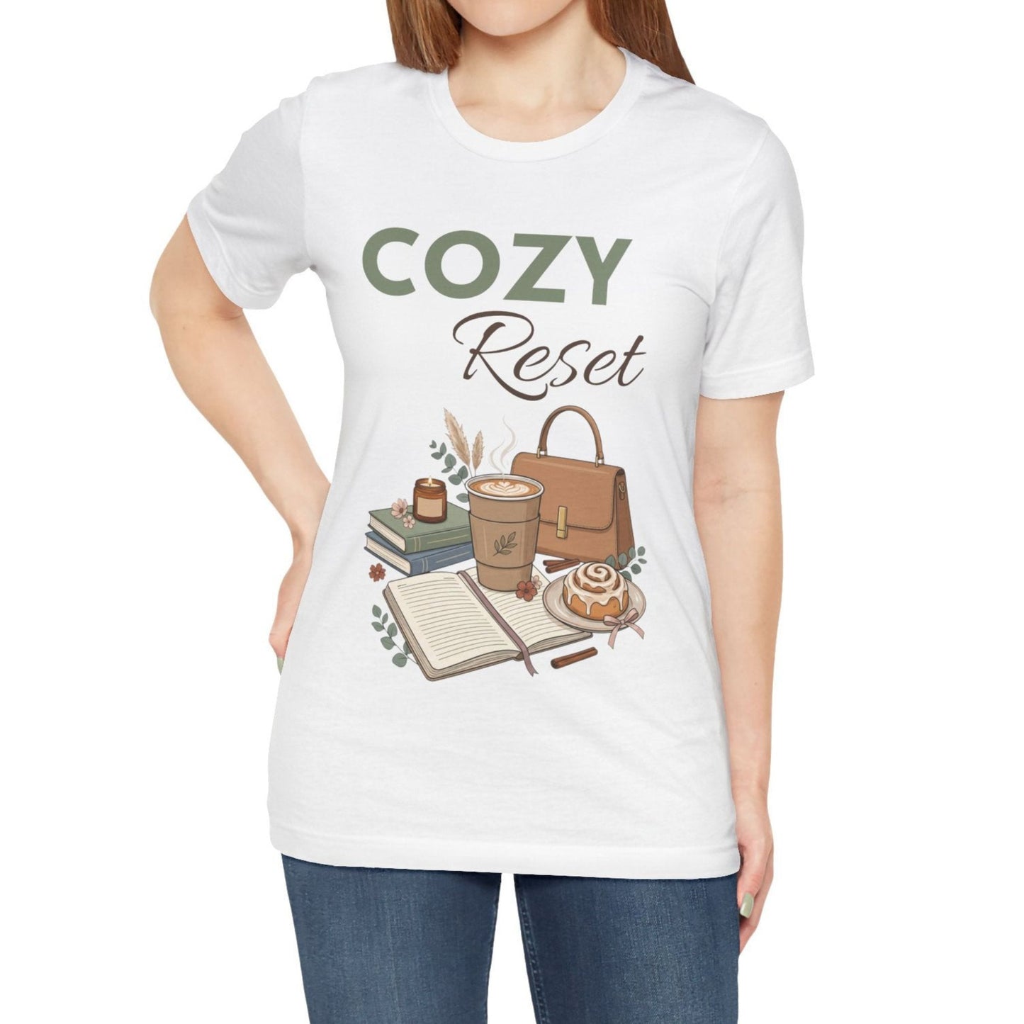 A woman is wearing a white t-shirt with 'Cozy Reset' on the front.