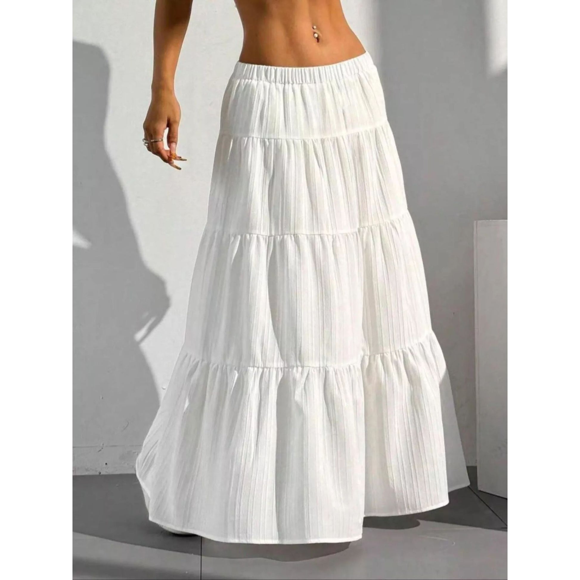 White tiered skirt worn by a person against a neutral background