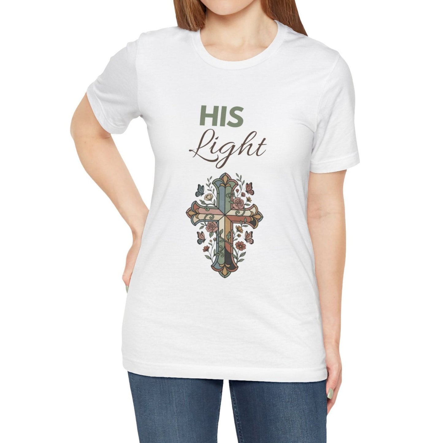 White t-shirt with a cross design and 'His Light' text worn by a person on a white background